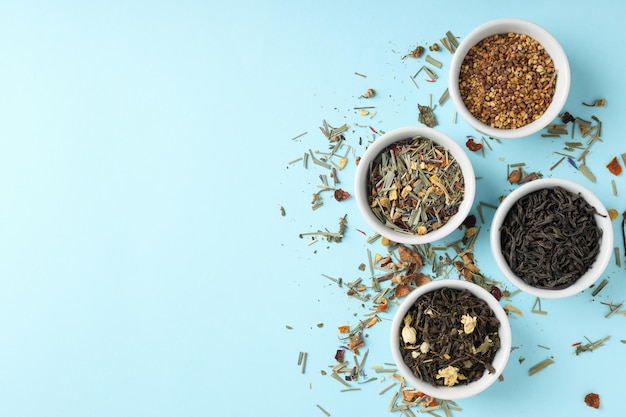 Concept of cooking tea with different types of tea on blue background