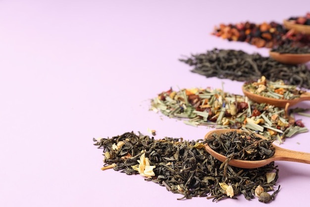 Concept of cooking tea with different types of tea on purple background