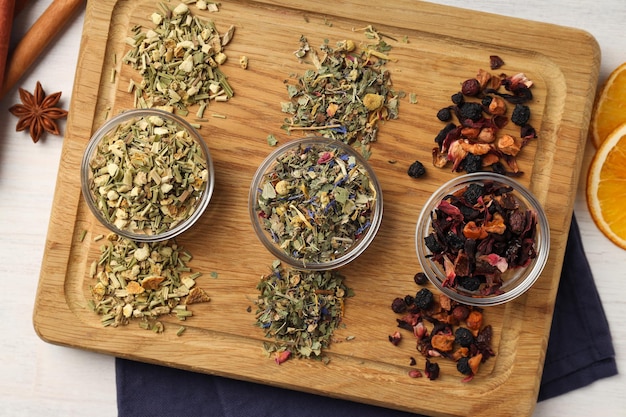 Concept of cooking tea with different types of tea on white wooden background