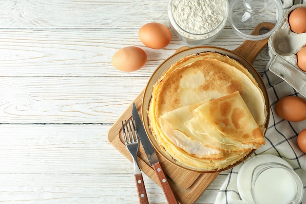 Concetto di cucinare con crepes su un tavolo di legno bianco