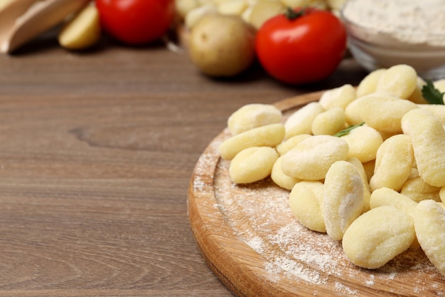 Concept of cooking with potato gnocchi on wooden background