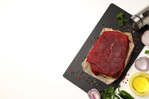 Photo concept of cooking with raw beef steak on white background