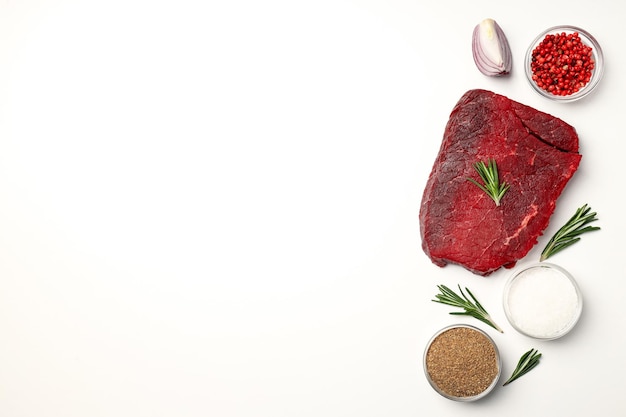 Concept of cooking with raw beef steak on white background