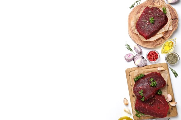 Concept of cooking with raw beef steaks on white background