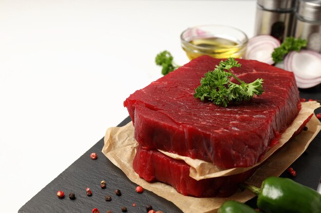 Concept of cooking with raw steak on white background