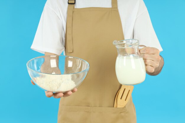 Concept of cooking with young man on blue background