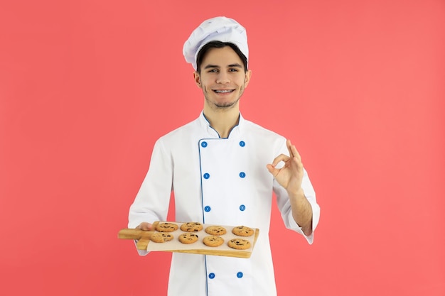 Concept of cooking young man chef on pink background