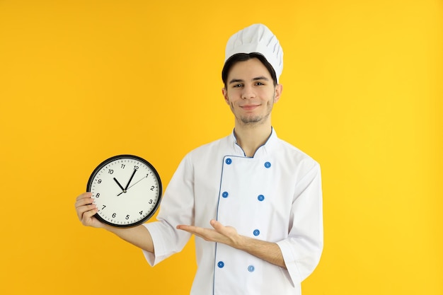 Concept of cooking young man chef on yellow background