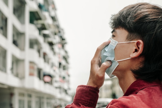 Concept of coronavirus quarantine Coronavirus 2019nCoV man with mask in the city Air pollution