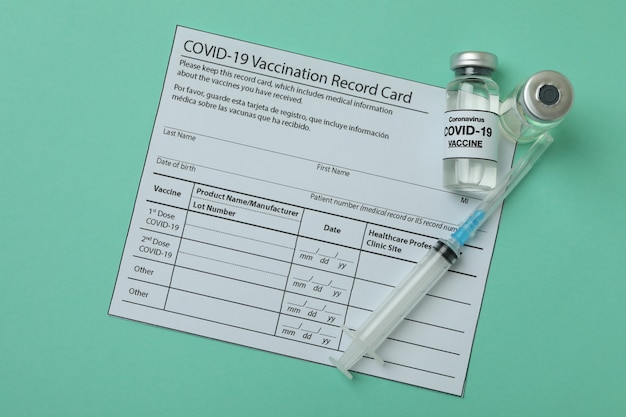 concept of covid - 19 vaccination with vials of vaccine on mint