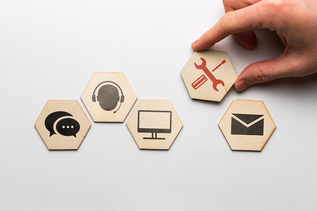 Il concetto di creare un servizio clienti e supporto da icone su blocchi di legno.