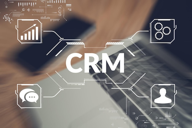 Concept CRM or Customer Relationship Management. Abstract scheme of work on the background of a laptop and a phone.