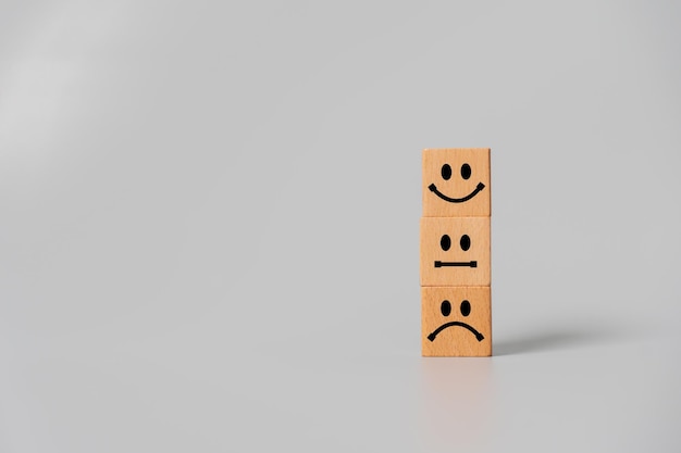 Concept of customer satisfaction review wooden blocks with facial expression