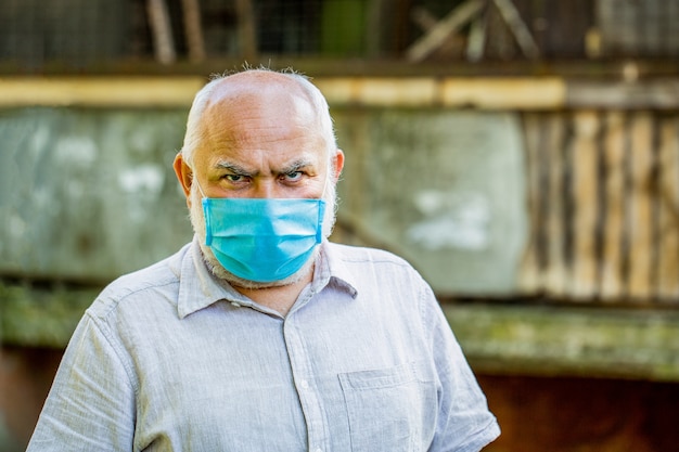 Concetto pericolo di coronavirus per gli anziani. ritratto di un uomo anziano con una benda chirurgica, coronavirus, maschera medica.