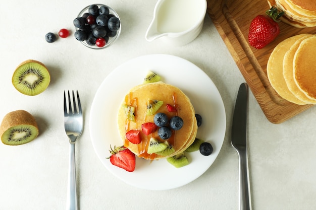 Concept of delicious dessert with pancakes on white textured table