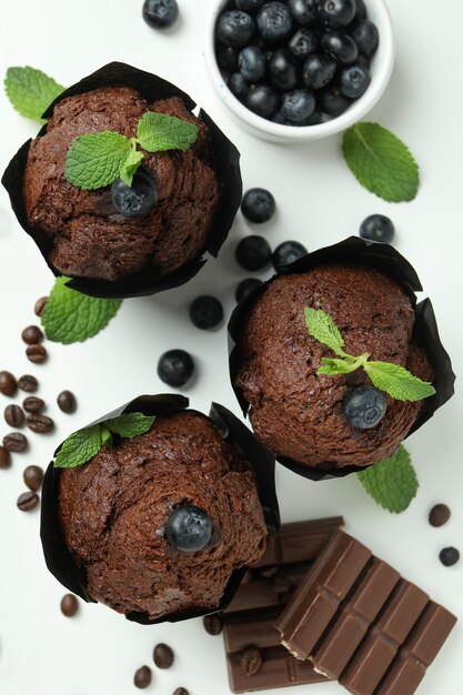 Concept of delicious food with chocolate muffins on white background.