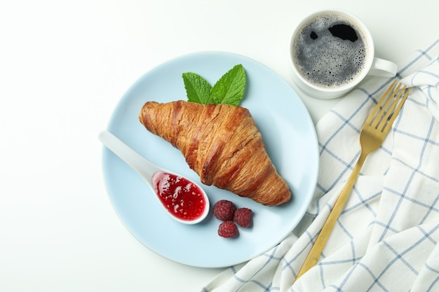 Concept of delicious food with croissant with raspberry jam on white background