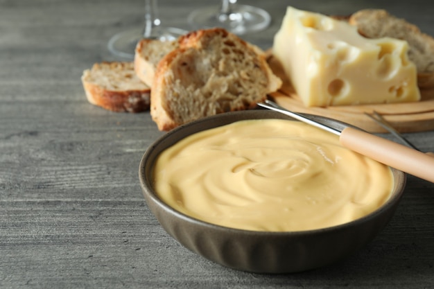 Concept of delicious food with fondue on gray textured table