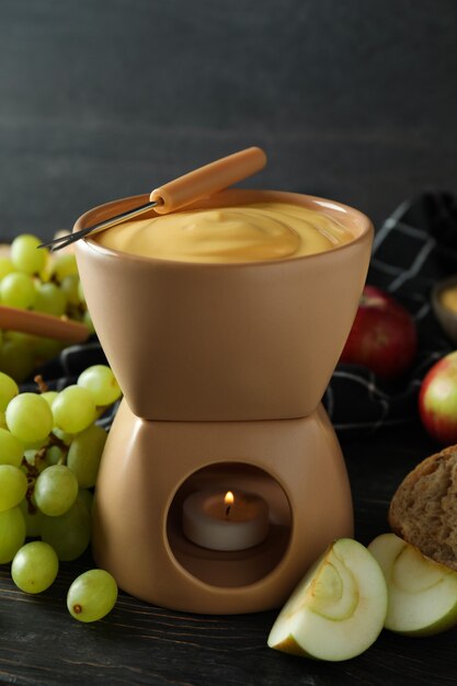 Concept of delicious food with fondue on wooden table