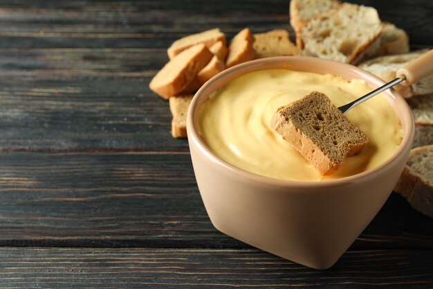 Concept of delicious food with fondue on wooden table