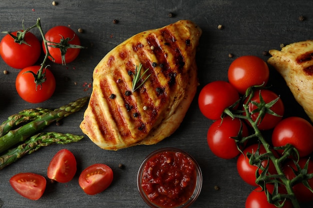 Concept of delicious food with grilled chicken meat on dark wooden