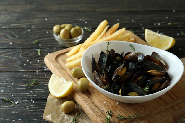 Concept of delicious food with mussels on wooden table