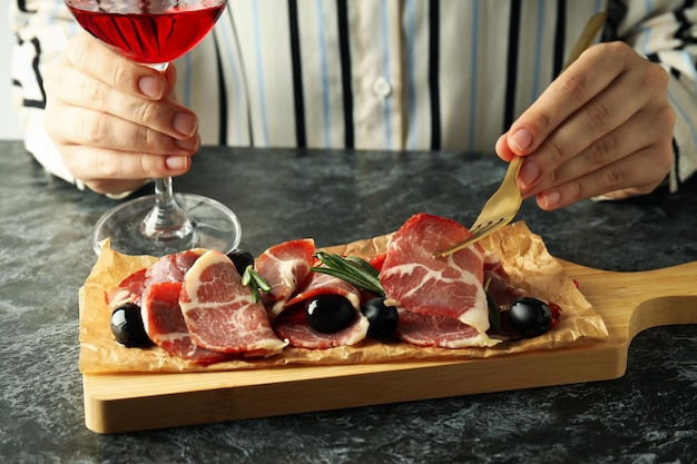 Concept of delicious Spanish cuisine jamon on dark smokey table