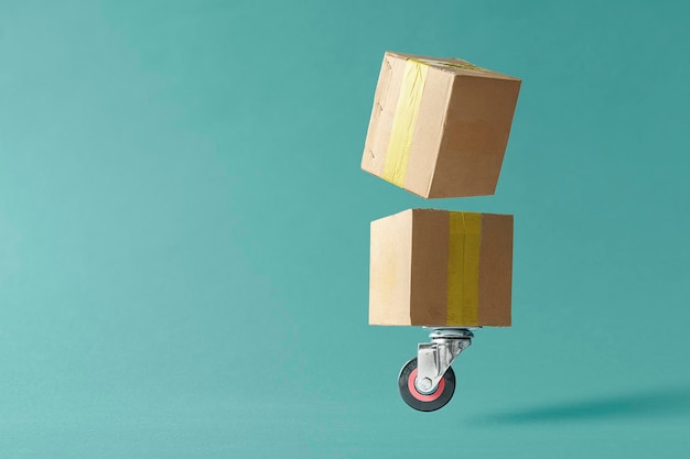 Photo concept delivery and logistics on a blue background with a copy space cardboard boxes on a wheel from a shopping cart