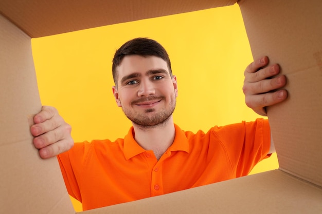 Concept of delivery surprise gift young man opened a cardboard box