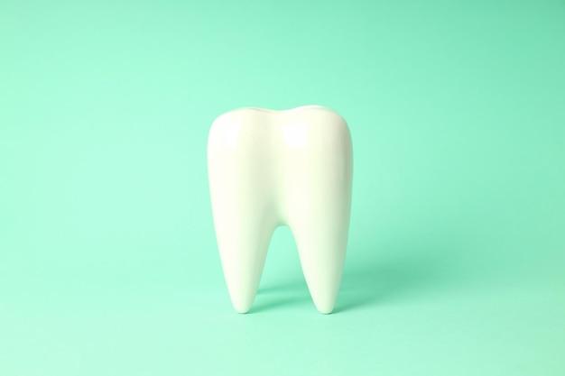 Photo concept of dental care tooth on mint background