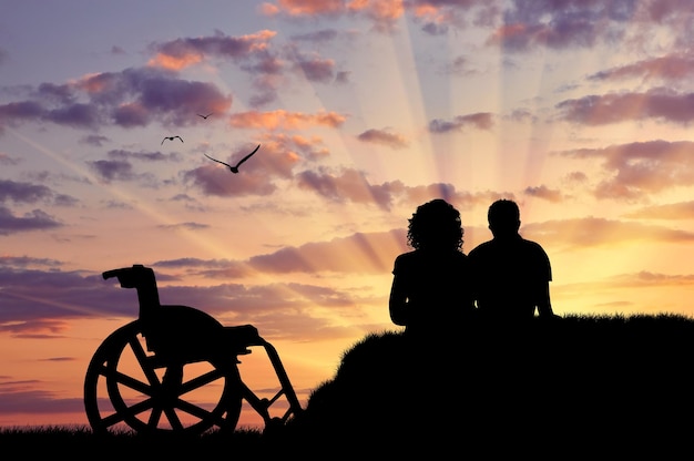 Foto concetto di disabilità e malattia. sagoma di persona disabile con il guardiano sullo sfondo del tramonto