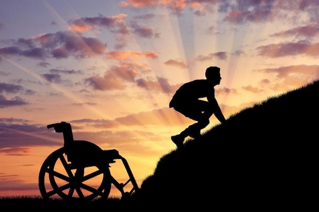 Concept of disability and self-motivated. Silhouette of disabled person to climb the hill at sunset