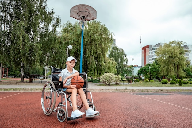 Concept of disabled child, support, rehabilitation, disabled person, paralyzed, happy disabled child. Disabled boy at school on the sports ground.