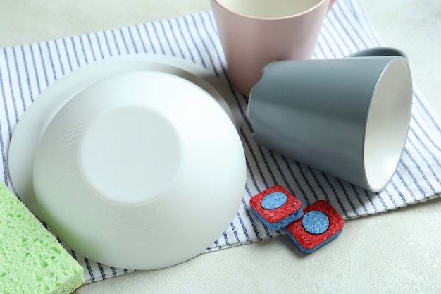 Концепция аксессуаров для мытья посуды на белом текстурированном столе