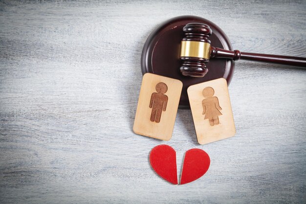 Photo concept of divorce. male and female wooden symbols, red heart and judge gavel