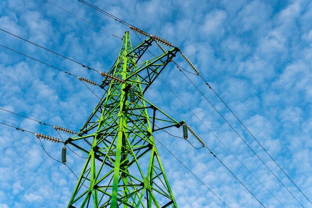 Photo concept of ecological energy. green transmission tower and beautiful blue sky.