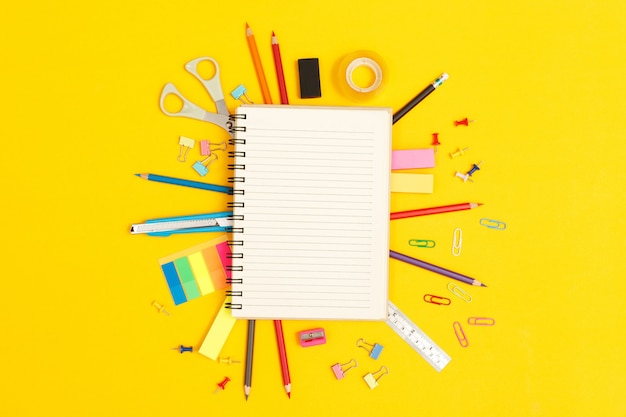 Concept of education top view notebooks and accessories stationery studying in the library at school yellow background