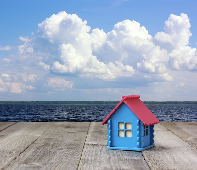 Foto concept: een klein blauw houten huis aan zee.