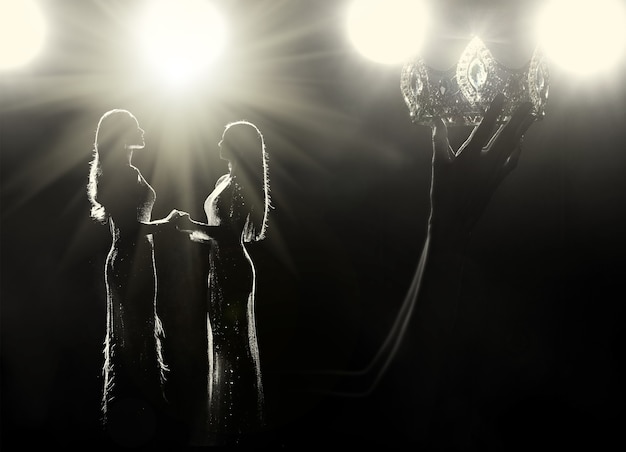 Concept elke Girls Dream to be Miss missverkiezing koningin Universe wedstrijd. Vrouwen oorlogsschepen heffen Diamond Silver Crown op als uiteindelijke winnaar op het podium, studioverlichting met verlicht licht flare silhouet