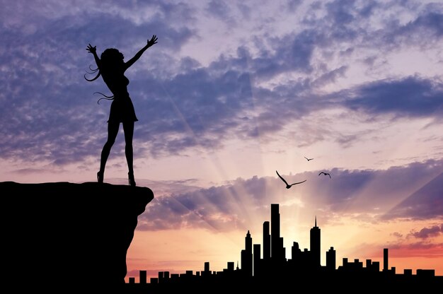 Photo concept of emotion. silhouette of a happy girl looking at urban sunset