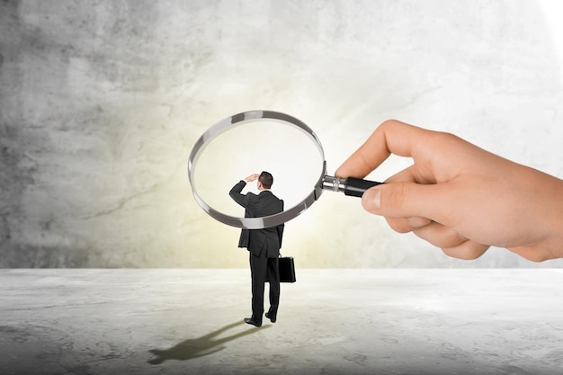 concept of employee monitoring by boss, hand with magnifying glass