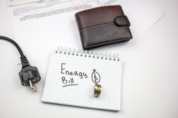 The concept of an energy bill for electricity utilities heating\
the inscription energy bill wallet wire and receipts the cost of\
electricity energy payment for services