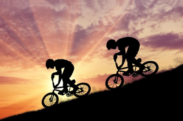 Concetto di sport estremi. silhouette di due ciclisti in movimento al tramonto