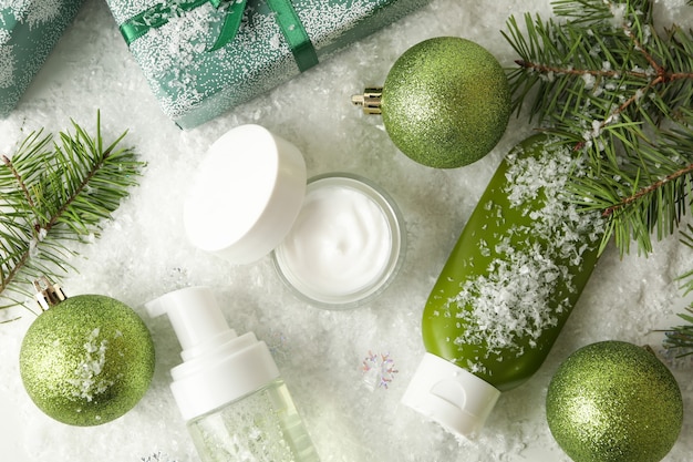 Concept of face care with cosmetics on background with decorative snow