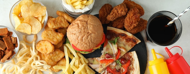 Concept of fast food on white textured table