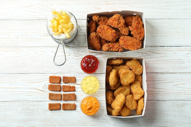 Photo concept of fast food on white wooden table