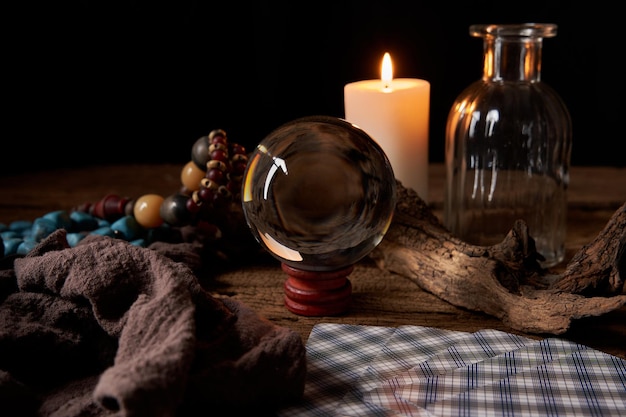 concept fortune-telling on a wooden table and candle with a crystal ball and tarot cards background