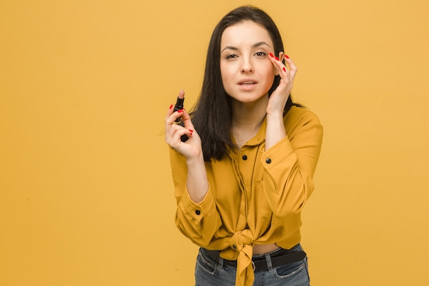 Concept foto van schattige vrouw make-up en houdt lippenstift