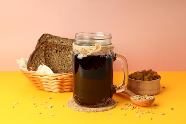 Concept of fresh drink on orange table against pink background kvass