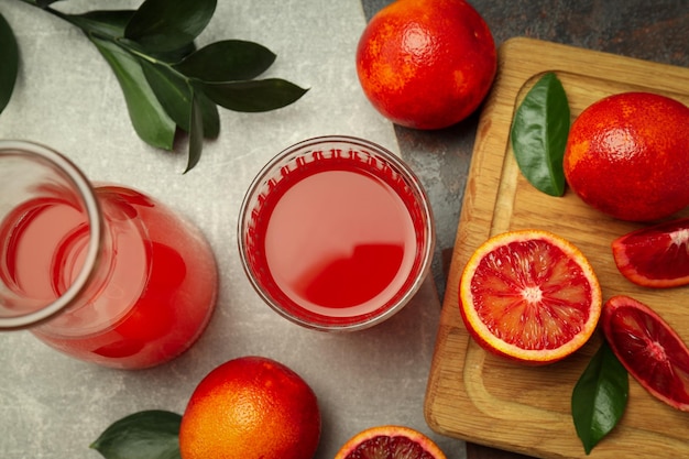 회색 질감 테이블에 붉은 오렌지 주스와 함께 신선한 음료의 개념